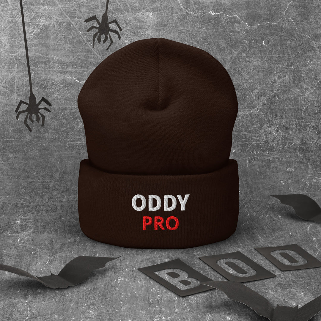 Oddy Pro cuffed beanie displayed on a textured background with Halloween-themed elements.
