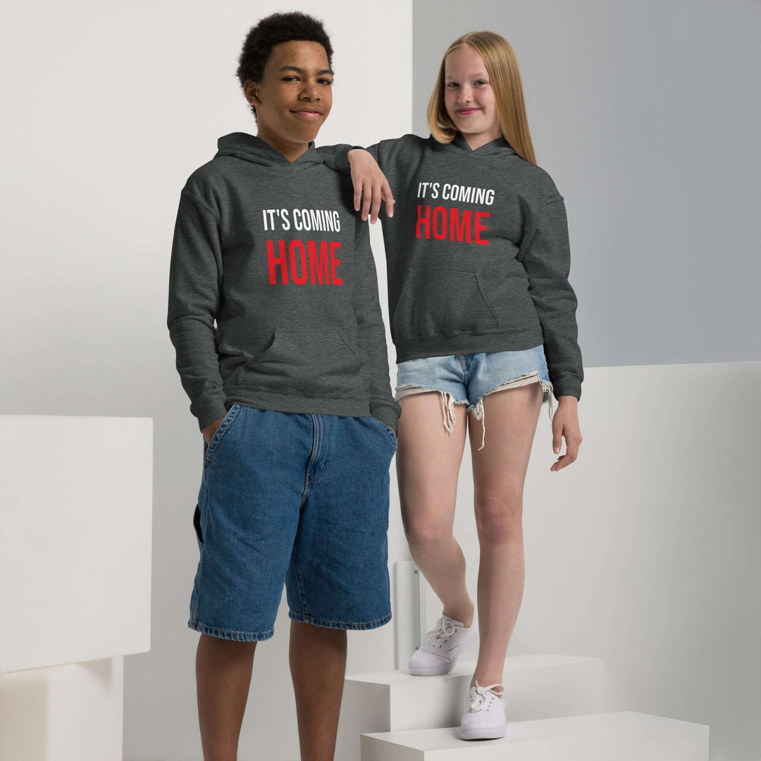 Two children wearing It's Coming Home Youth heavy blend hoodies in a stylish indoor setting.