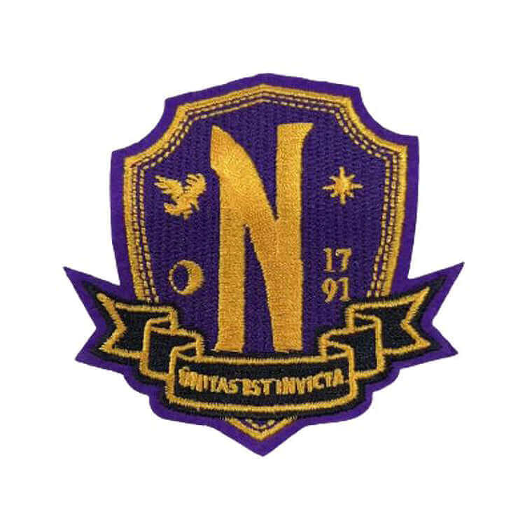 Wednesday Nevermore Academy Welcome Kit embroidered patch featuring shield, letter N, and motto UNITA EST INVICTA.